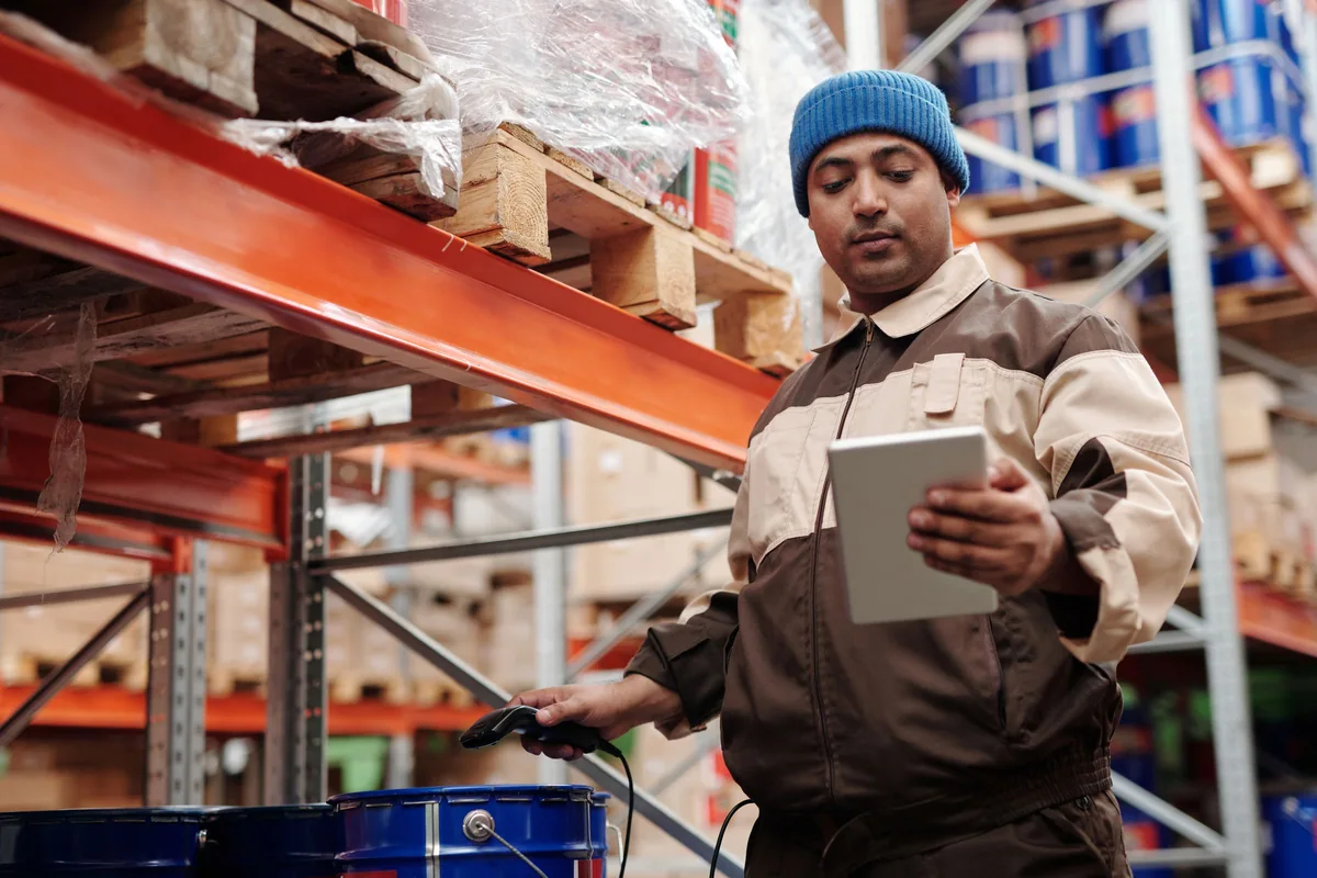 Warehouse worker checking inventory on a digital tablet.
